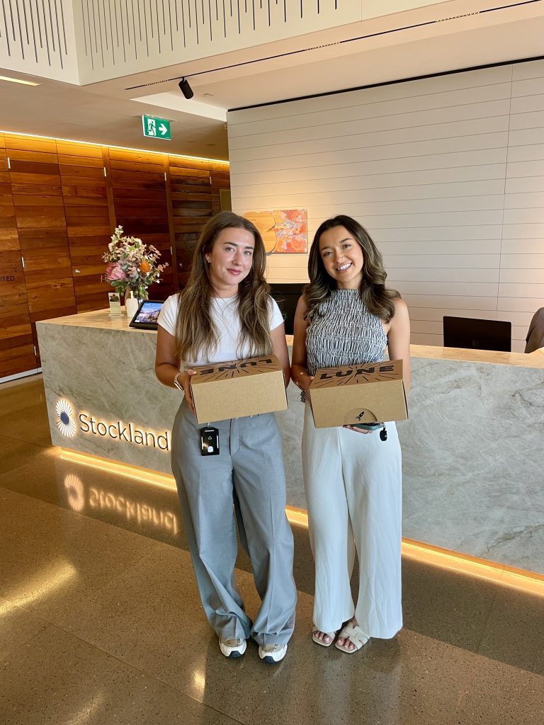 Picture of two temp contractors in reception holding boxes of Lune